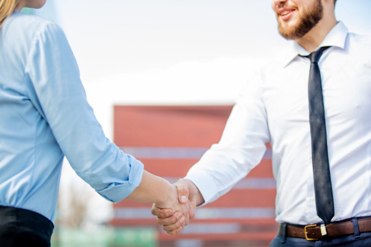Busninesswoman and businessman have a shake hands Busninesswoman and businessman have a shake hands on city outdoor.