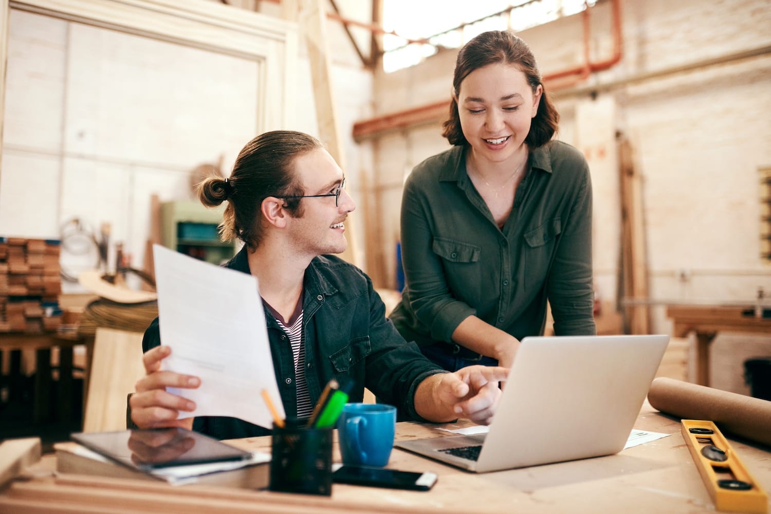 smiling woman wearing glasses placing freshly baked pastry